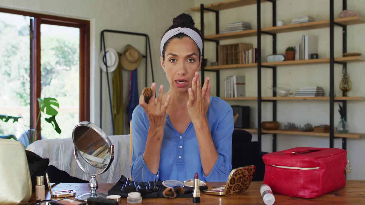 retrato de una vlogger de raza mixta aplicando maquillaje en casa