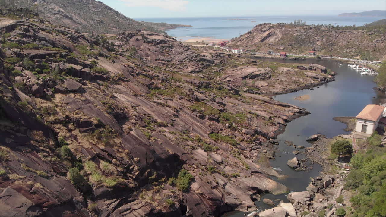 Drone Revealing Shot Of The Majestic Ezaro Waterfall In Dumbria, La Coruna, Spain With Water Flowing To The Calm Sea