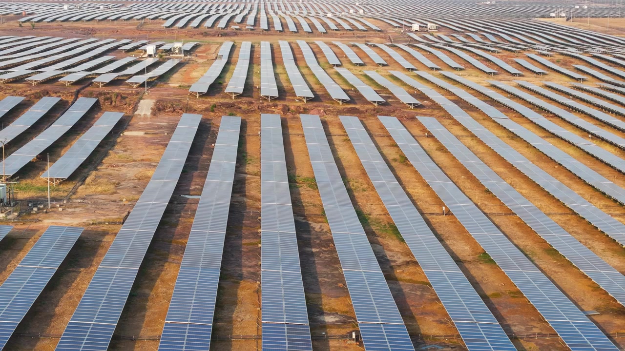 Drone tipper opad og afslører en stor fotovoltaisk solcellepark ved den gyldne time. Vedvarende energi, ren elektricitet, bæredygtig teknologi, storskala infrastruktur og grøn energi i Indien