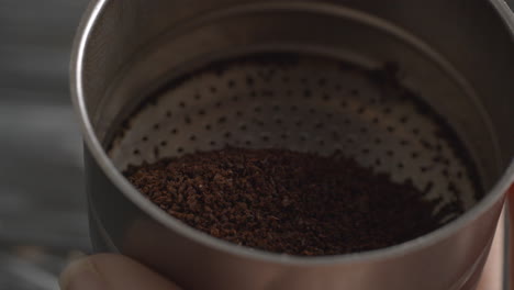 filling in funnel with ground coffee for moka pot