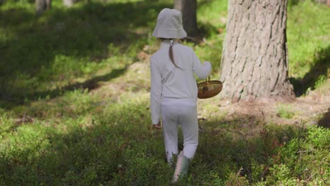 Ein-Junges-Weibliches-Kind,-Das-Im-Sommer-Mit-Einem-Korb-Im-Wald-Spazieren-Geht-Und-Blaubeeren-Und-Pilze-Pflückt