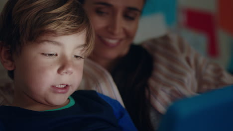 happy-little-boy-using-tablet-computer-with-mother-teaching-child-playing-games-on-touchscreen-technology-having-fun-before-bedtime