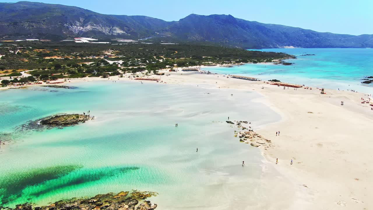 Birds eye view of Elafonisi lagoon, Crete, Greece showing tourists enjoying their vacations on a sunny day. Aerial