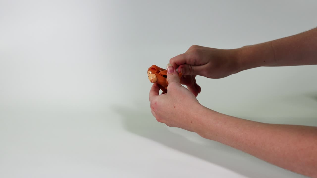 dos manos manipulando una figura de tigre de juguete