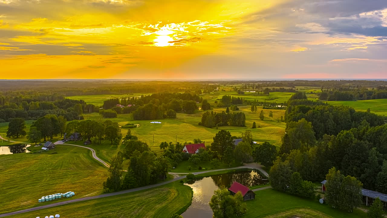 Clouds Rolling On Changing Color Sky At Sunset Over Green Farmland Fields. Timelapse