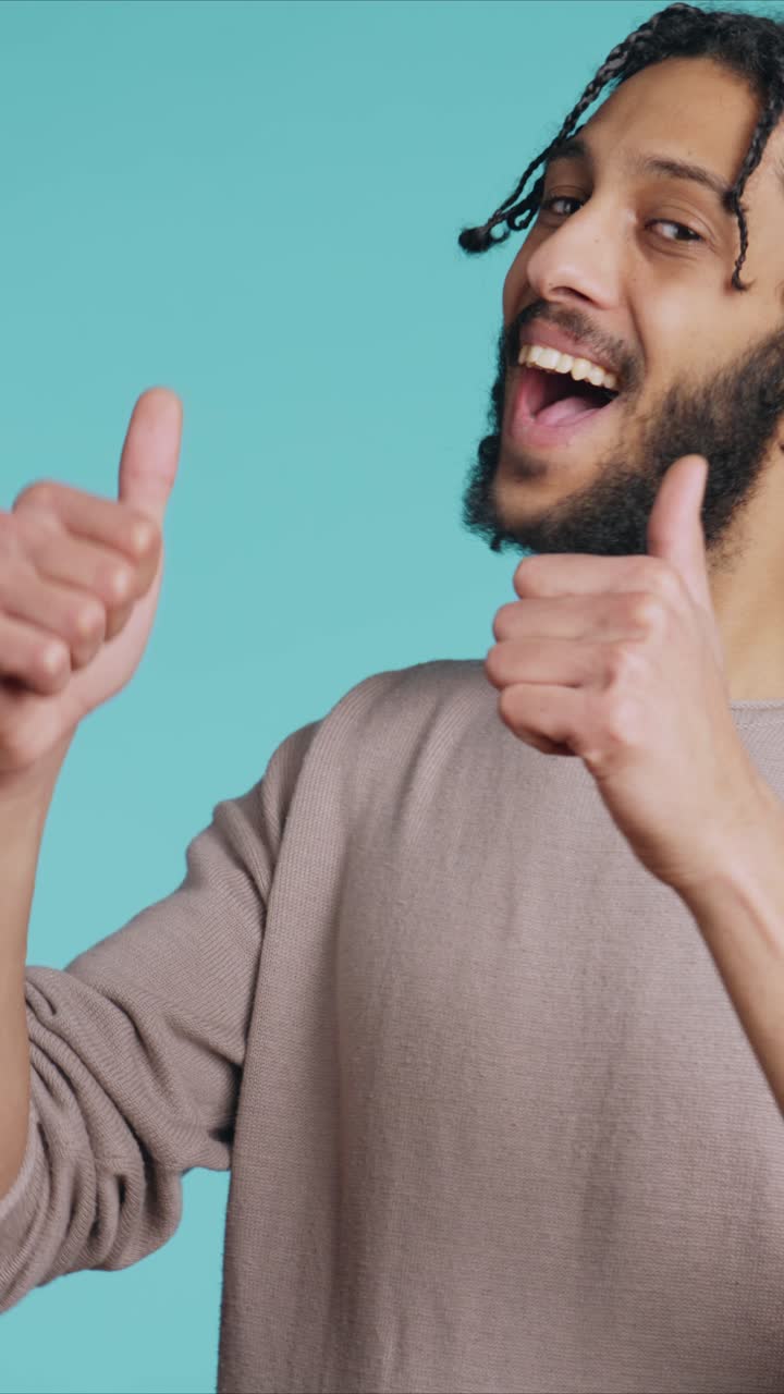 Vídeo vertical de um homem gesticulando com o polegar para cima, mostrando aprovação e demonstrando um humor positivo