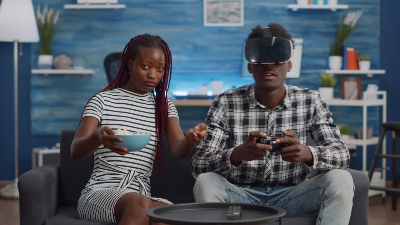 Black couple playing virtual game with vr glasses at home