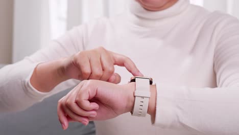 Close-up-shot-of-a-woman-hand-who-touch-and-scrolling-on-a-smartwatch-in-order-to-quickly-check-application-connect