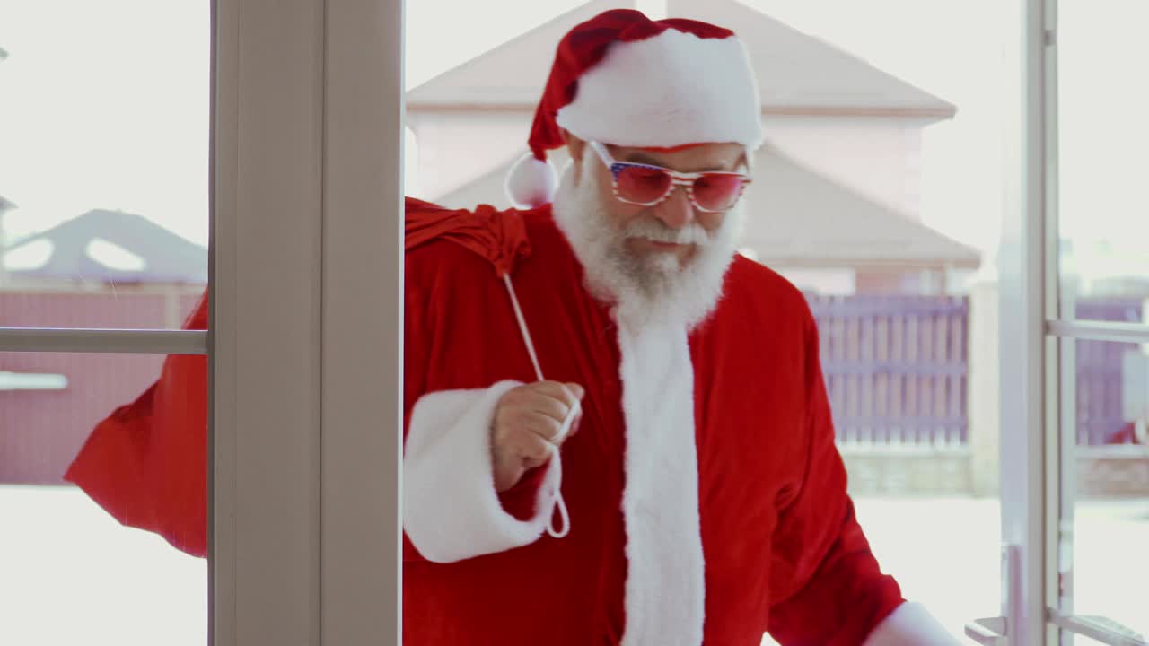 Babbo Natale con occhiali da sole divertenti entra in casa