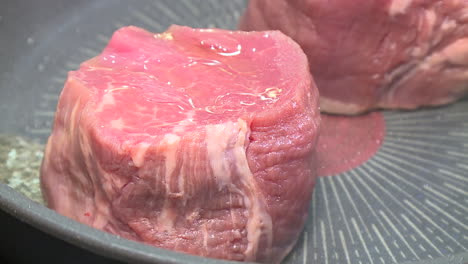 raw steak cooking in a pan