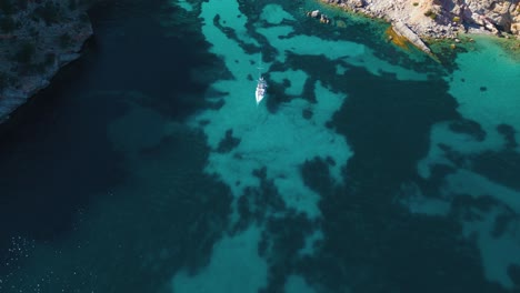 Pristine-turquoise-clear-water-beach-bay-with-yacht-ship-sailing-boat-at-on-Palma-de-Mallorca-Island