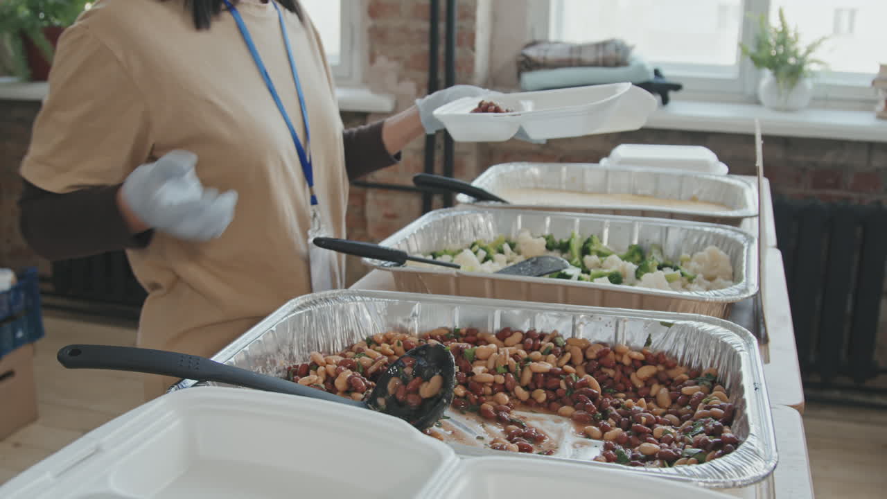 Volunteer Putting Food in Plastic Container