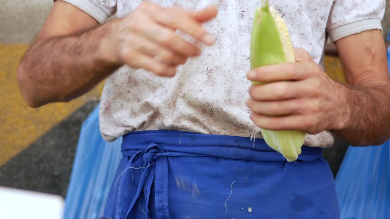 야외 시장 에서 옥수수 어리 를 준비 하는 사람