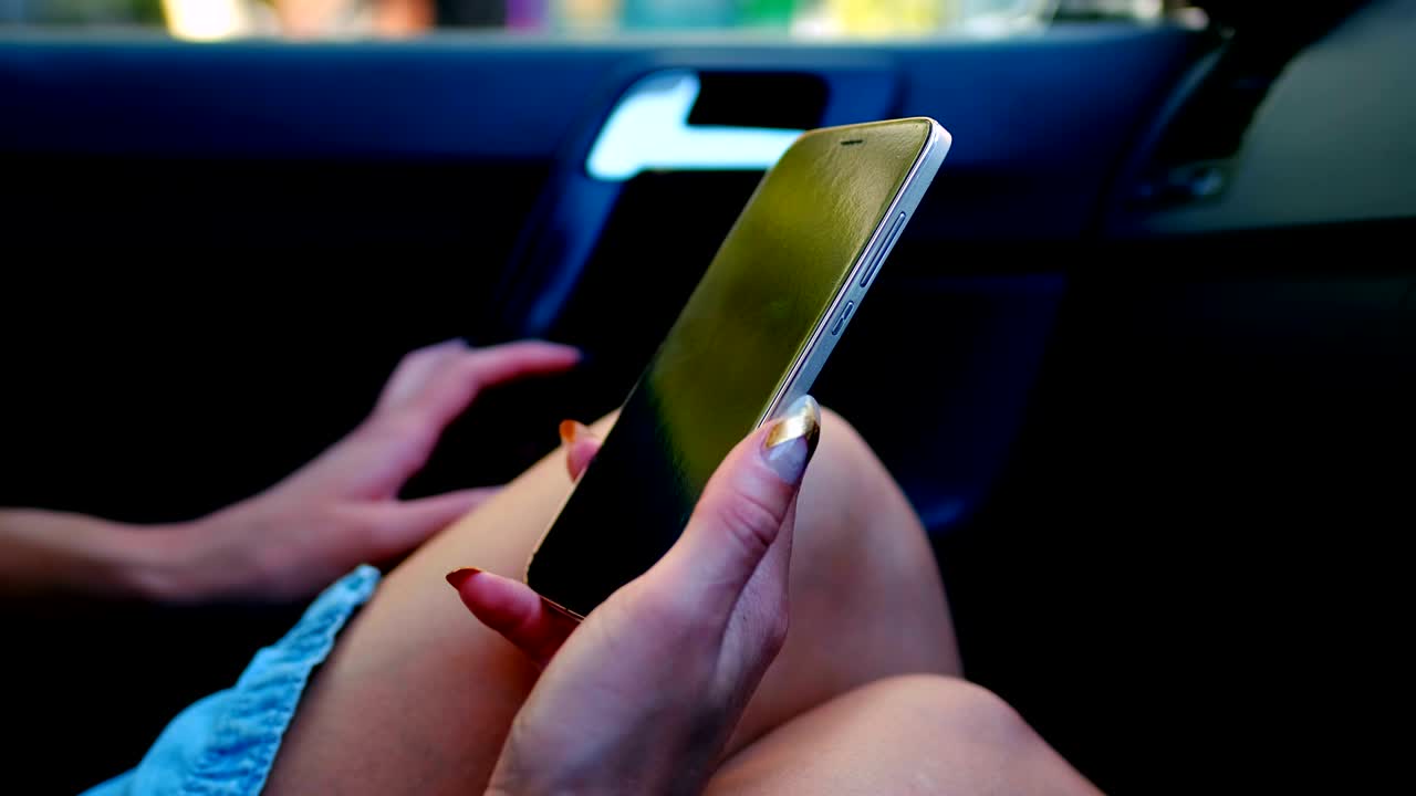 mujer de cabello rosa usando teléfono móvil en el coche 4k
