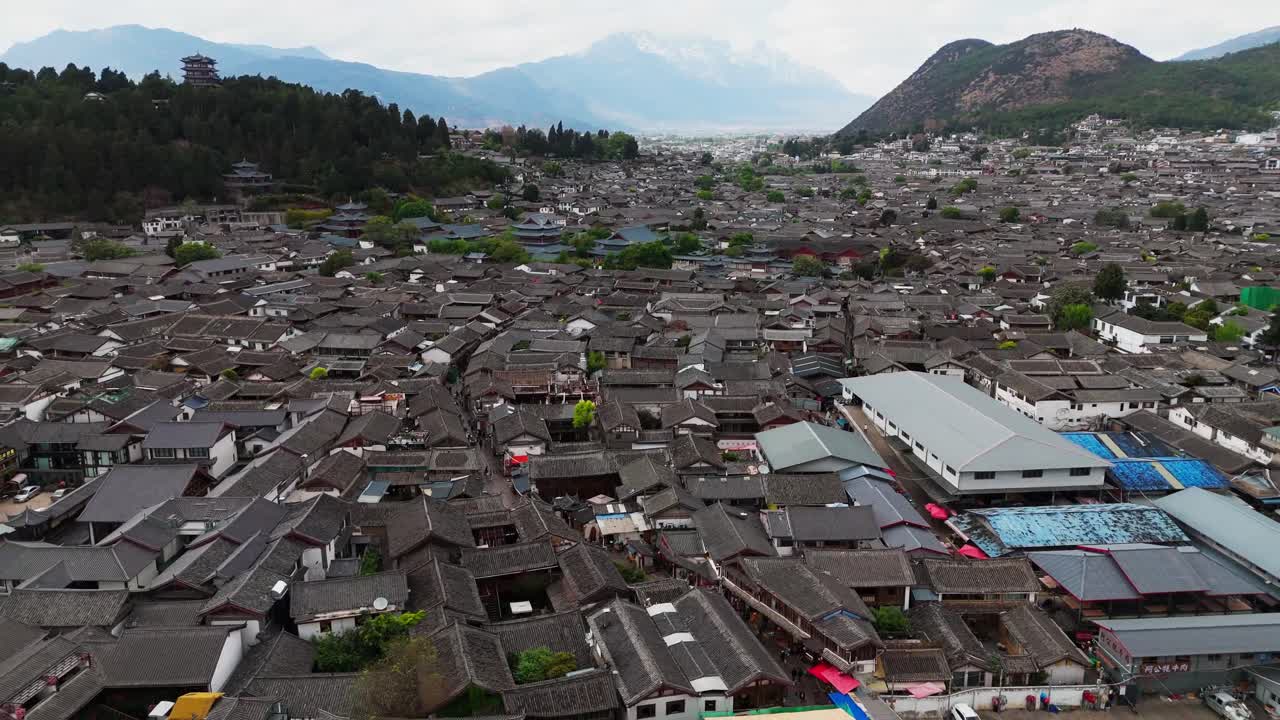 Dense rooftops of Lijiang Old Town stretch across historic district, pullback