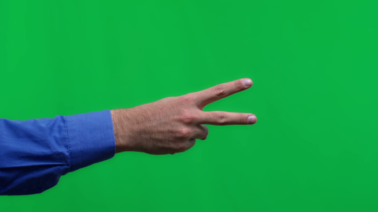 Human hand on a green background isolate, the person shows two fingers.