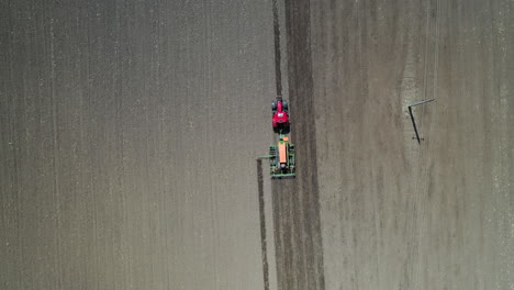 Red-tractor-driving-in-the-farm-field-filmed-from-above-in-hungary