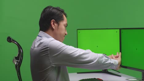 hombre estirándose en la computadora en la oficina