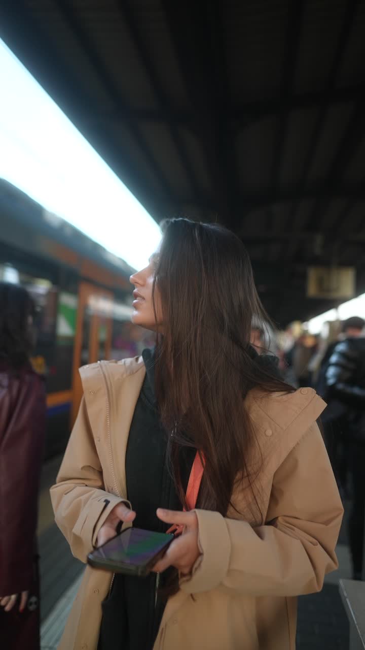 Woman using phone at train station