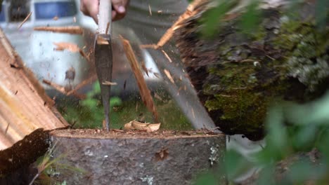 slow motion up close shot of a man splitting a log with an axe