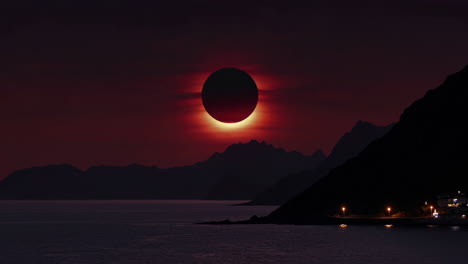 a dramatic view of a total solar eclipse over a dark mountainous landscape and water