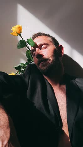 hombre con rosa amarilla a la luz del sol