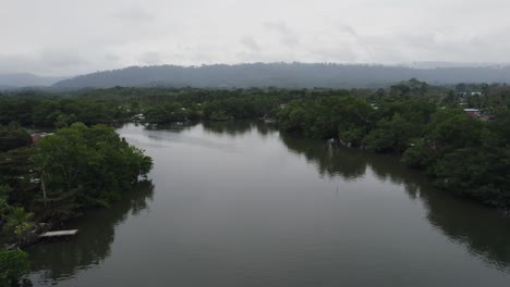 Calm-river-in-lush-greenery-under-cloudy-skies-in-Almirante,-Panama,-aerial-view