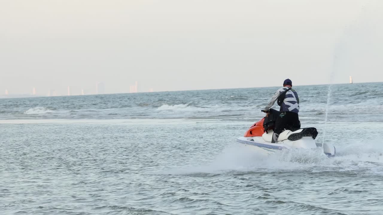 바다의 물결 을 가로질러 제트 스키 를 타고 있는 사람