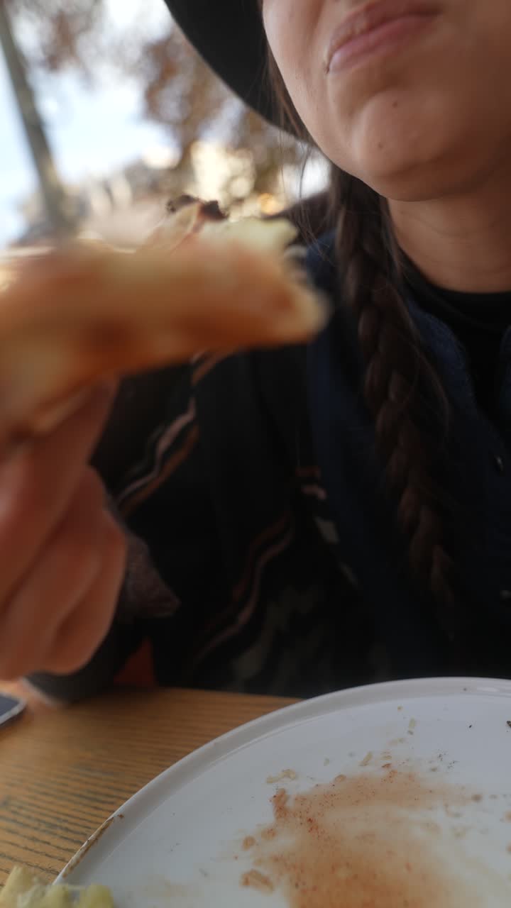 persona comiendo pizza al aire libre