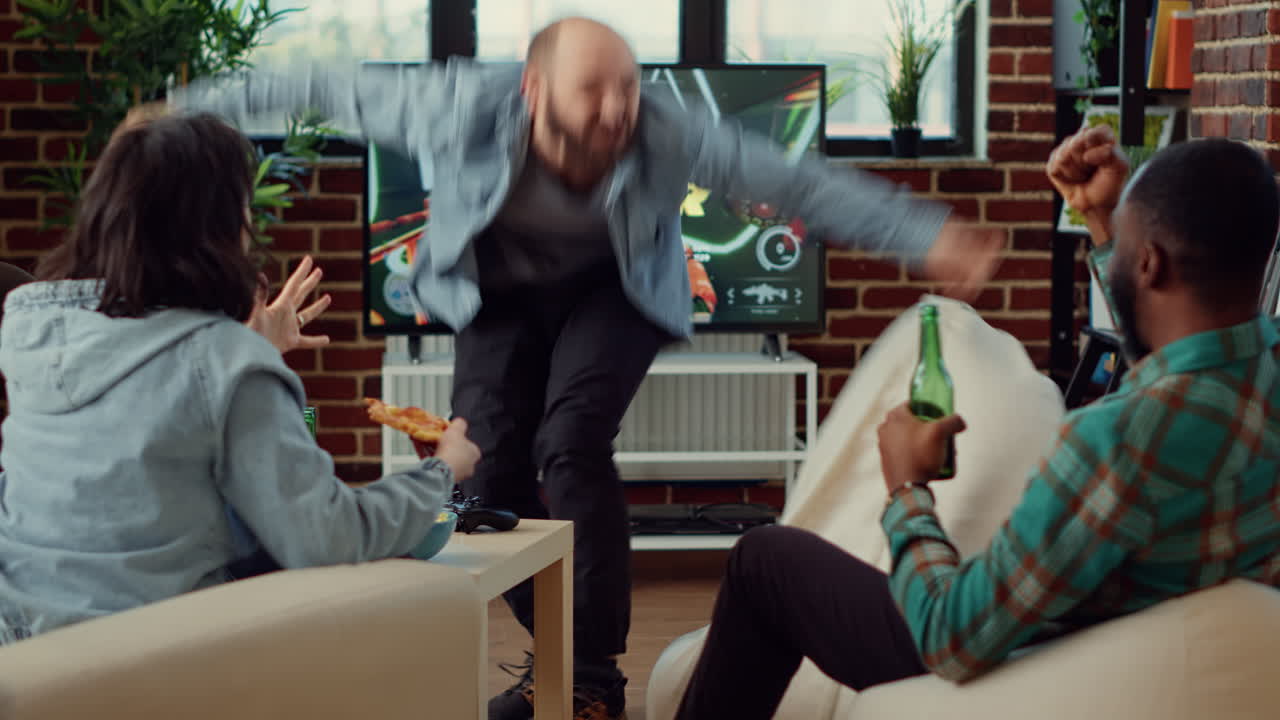 Happy man celebrating video games win with friends