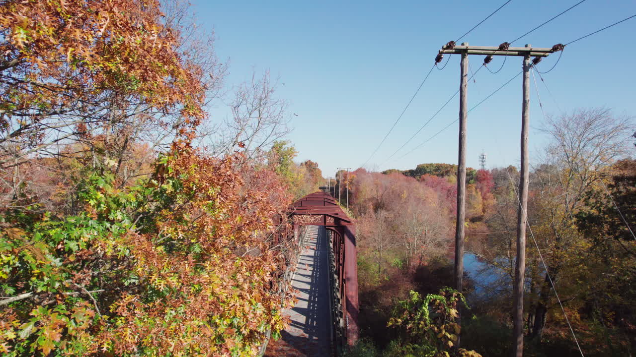 나무 들 사이 에 있는 웨스트 워릭 에 있는 트레일 트러스 다리 의 다채로운 가을 풍경