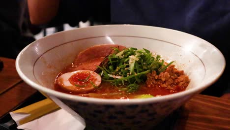 chopsticks lifting noodles from a ramen bowl