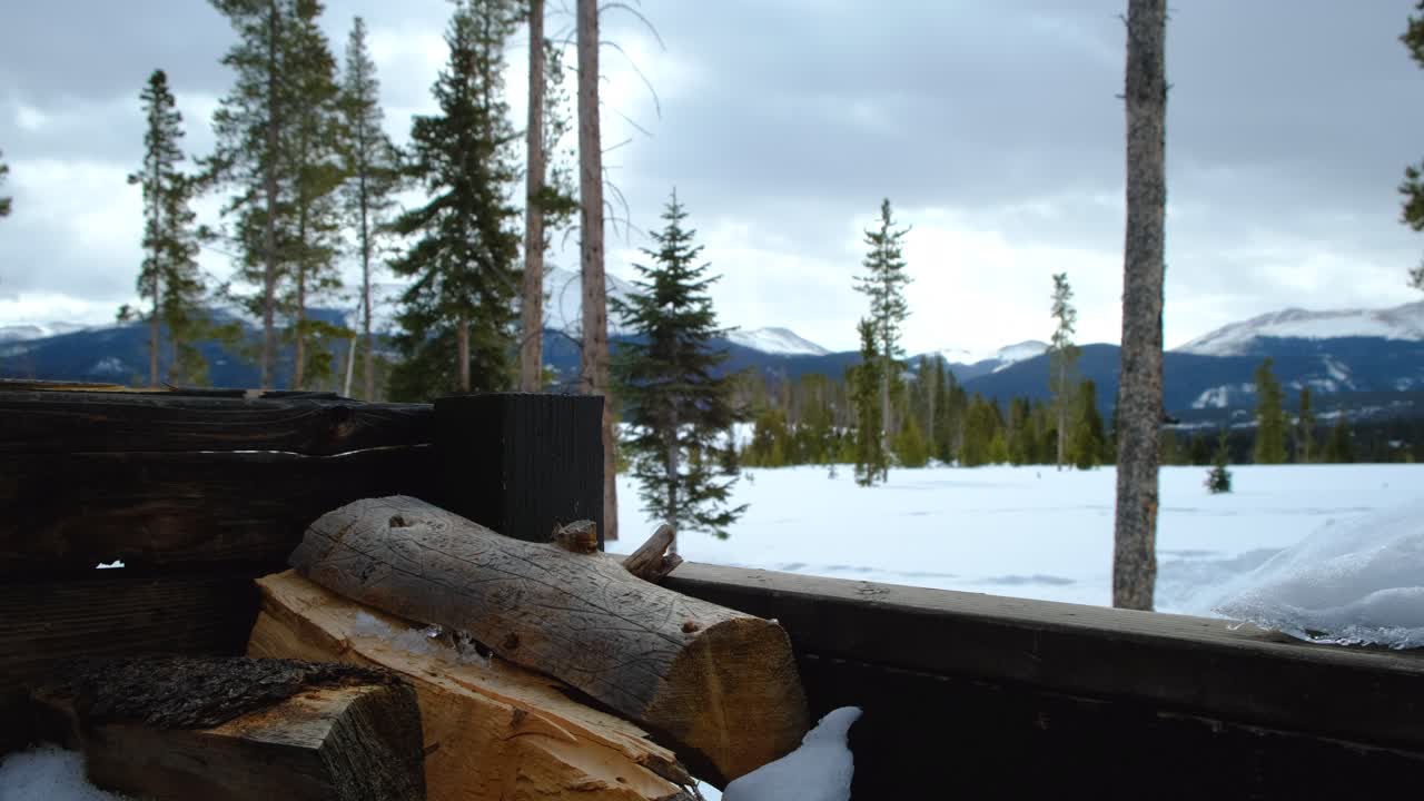 pila de leña - vistas de la cordillera - breckenridge, colorado - escena invernal en las montañas - cielo nublado cambiante, con rayos de sol brillando a través