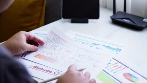 Close-up-of-a-dashboard-chart-and-hands-working-on-statistical-and-analytical-data