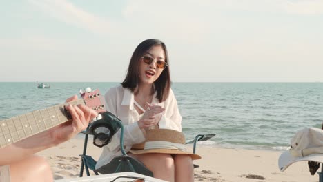 happy friend have fun playing guitar and clap in camp they smiling together in holiday on sand beach near camping tent