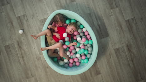 Friendly-girl-and-boy-siblings-have-fun-lying-in-dry-pool