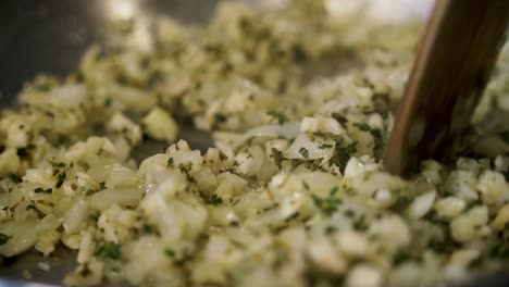 adding thyme to onions in a pan preparing ingredients to make vegan beyond meatballs with spaghetti and meat sauce