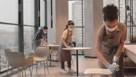 employees disinfecting surfaces in restaurant