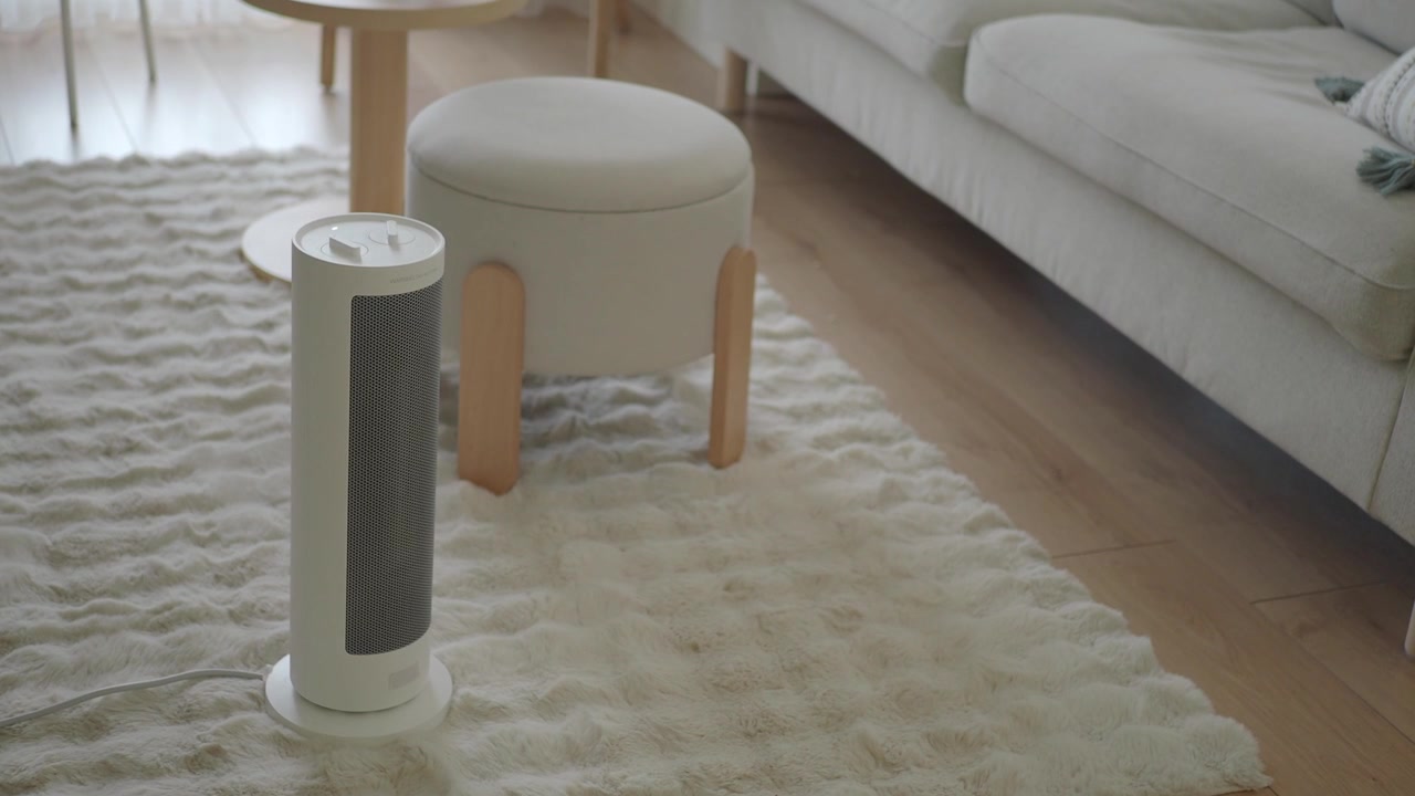 Moderne hvid el-radiator på et blødt tæppe i en hyggelig stue