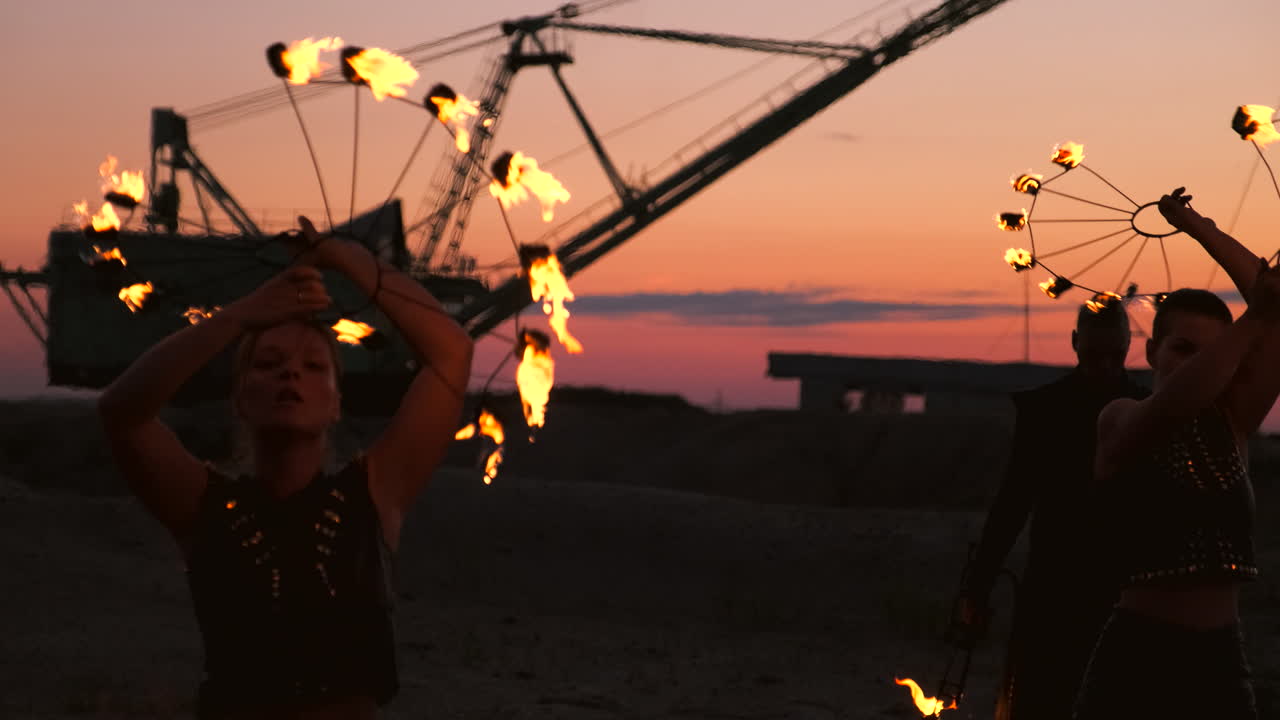 bailarines de fuego contra el atardecer. una joven posa con su aro de fuego contra la puesta de sol durante su actuación de baile