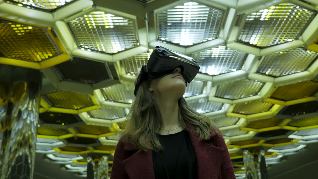 Žena s VR headsetem ve futuristickém vlakovém nádraží