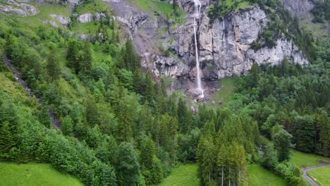 catarata de almenbach que fluye a través de la madera de pino y las rocas alpinas en kandersteg, suiza, aérea