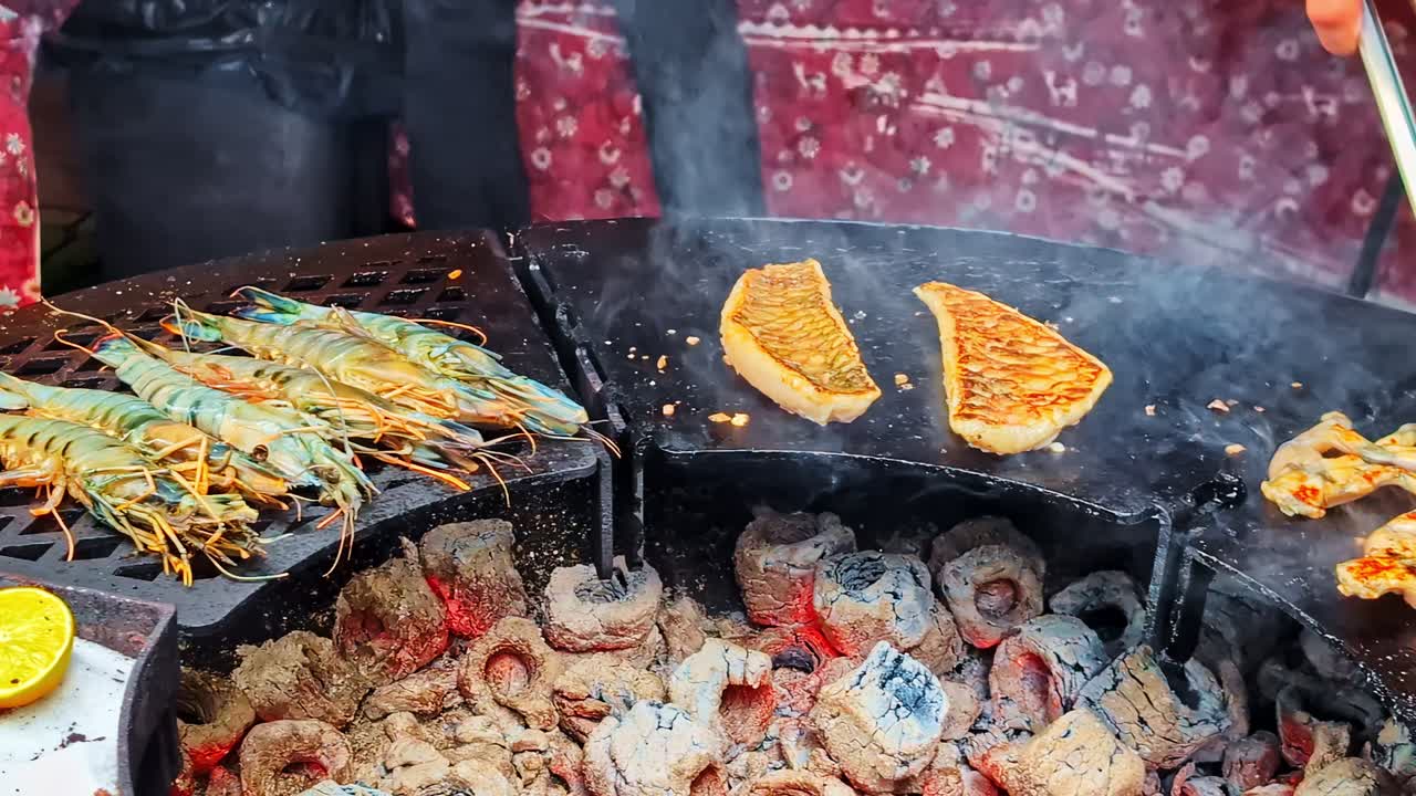 Grilled seafood plate with shrimp, prawns, frog legs and fish fillets over coals