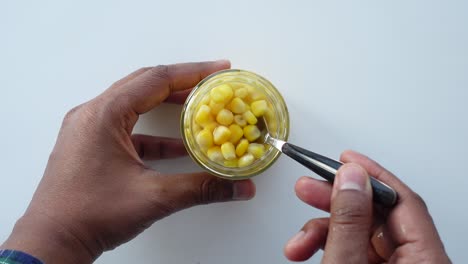 canned corn being served with a spoon