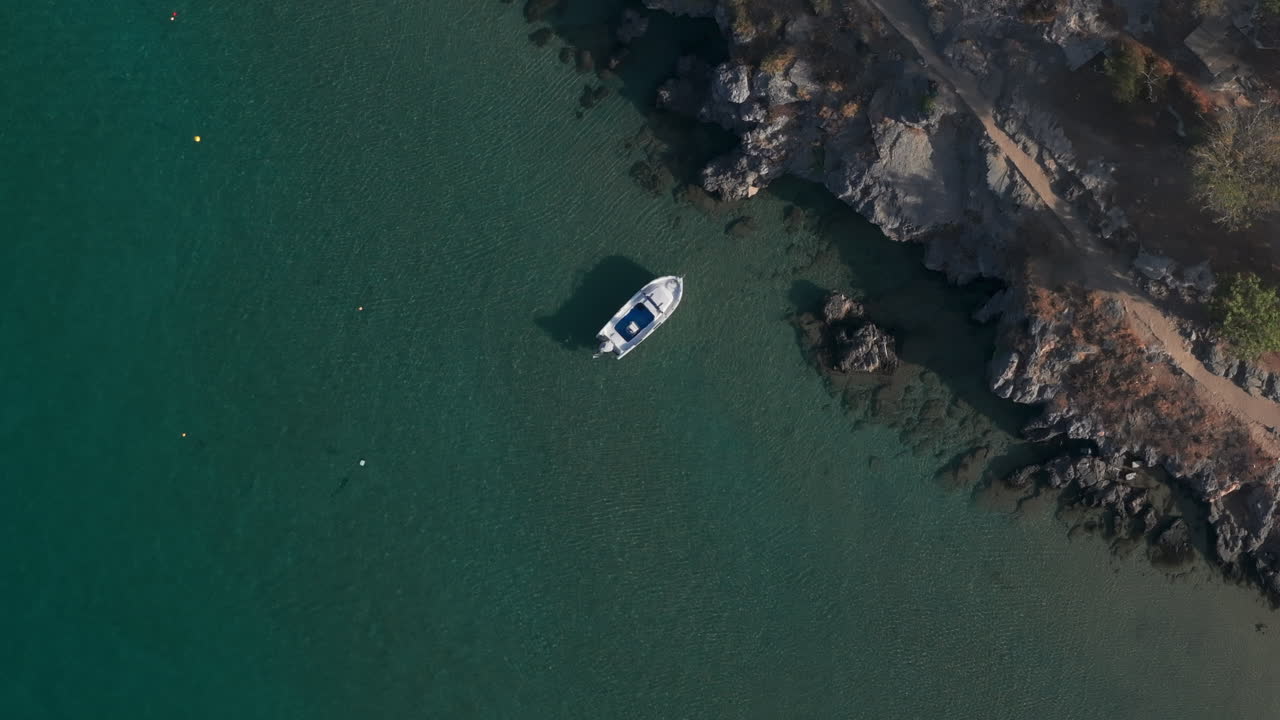 Ripresa aerea dall'alto su una piccola barca ferma in acqua limpida