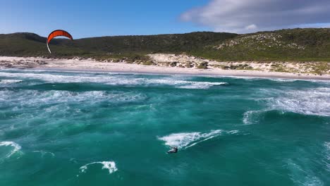 Slomo-Aufnahme-Eines-Mutigen-Kitesurfers,-Der-Eine-Welle-Startet-Und-Landet