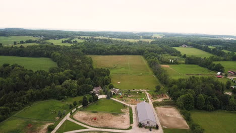 drone flying over a large horse farm and stable in the countryside