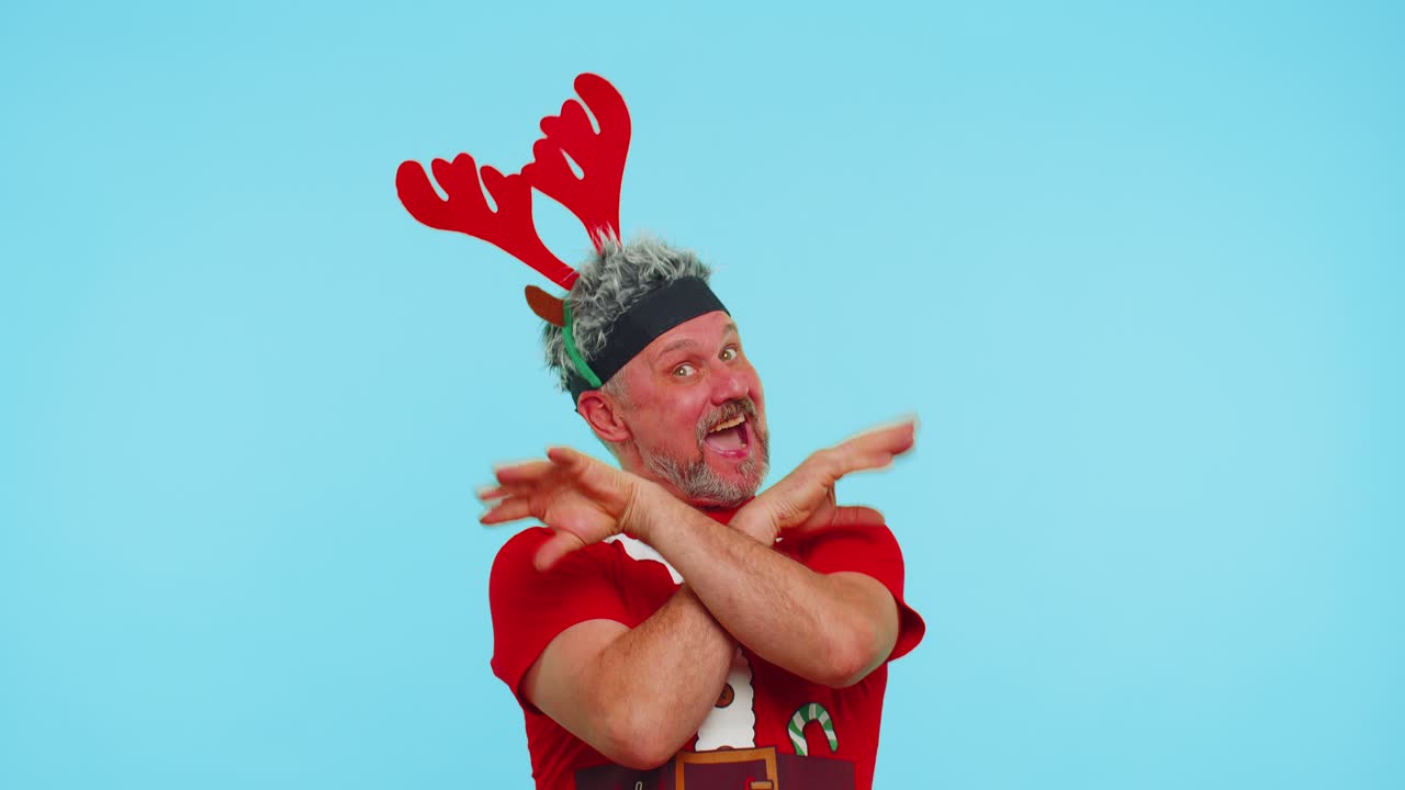 Man in christmas tshirt listening music via earphones dancing disco fooling around having fun