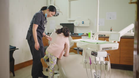 dentist calling little girl to examine her teeth