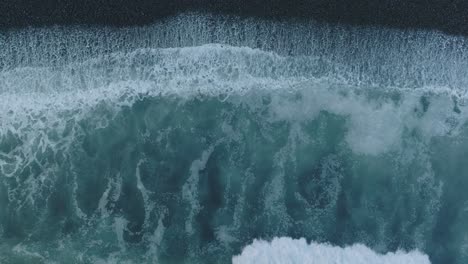 aerial top down drone abstract of shorebreak on black rocks el tunco el salvador